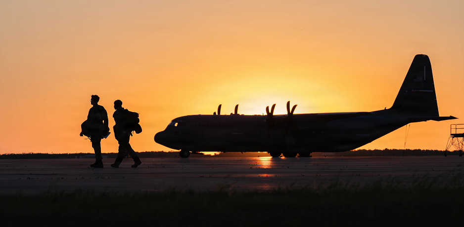 Silhouette of two pilots walking in front of a plane.